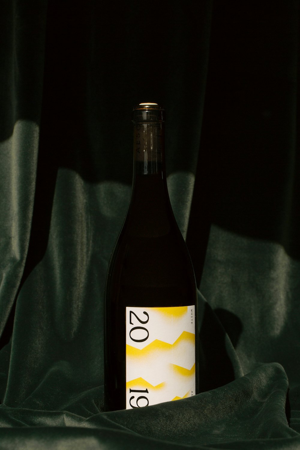 Bouteille de Chablis Vieilles Vignes posée sur une étoffe sombre